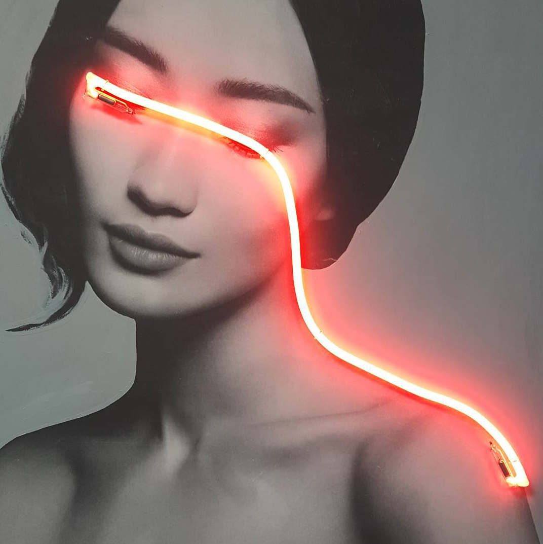 Neon light across a lady's eyes via Archillect